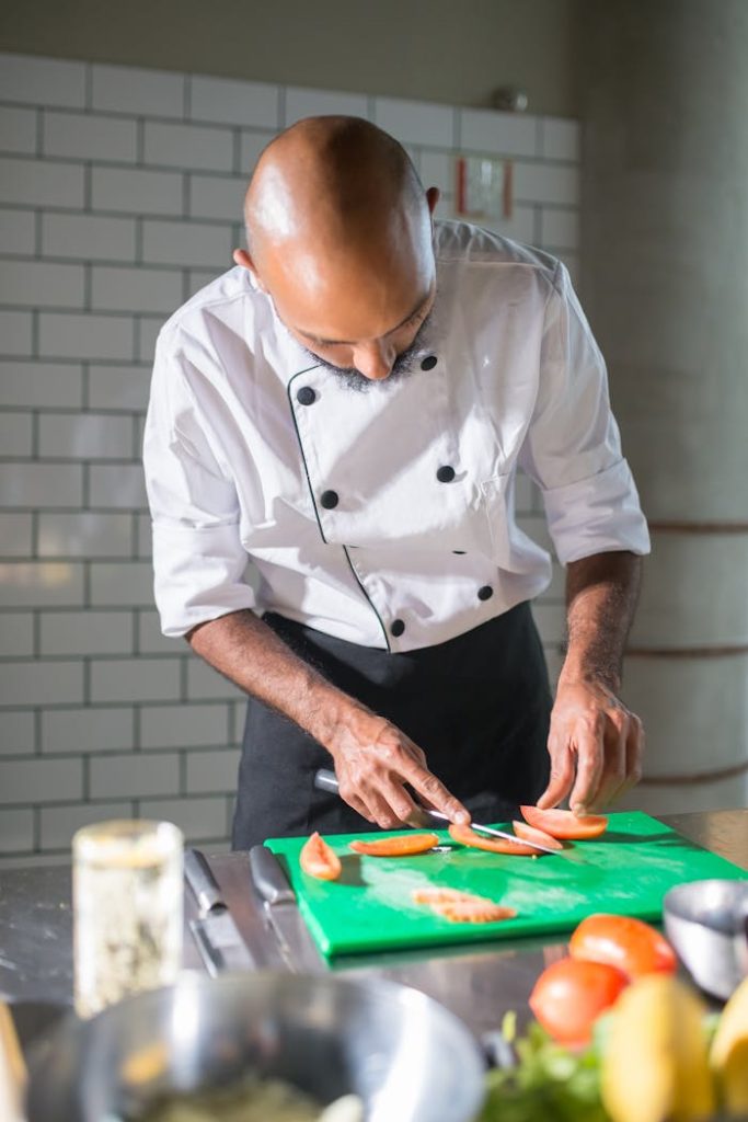 Chef skillfully slicing vegetables on a chopping board in a modern kitchen setting.