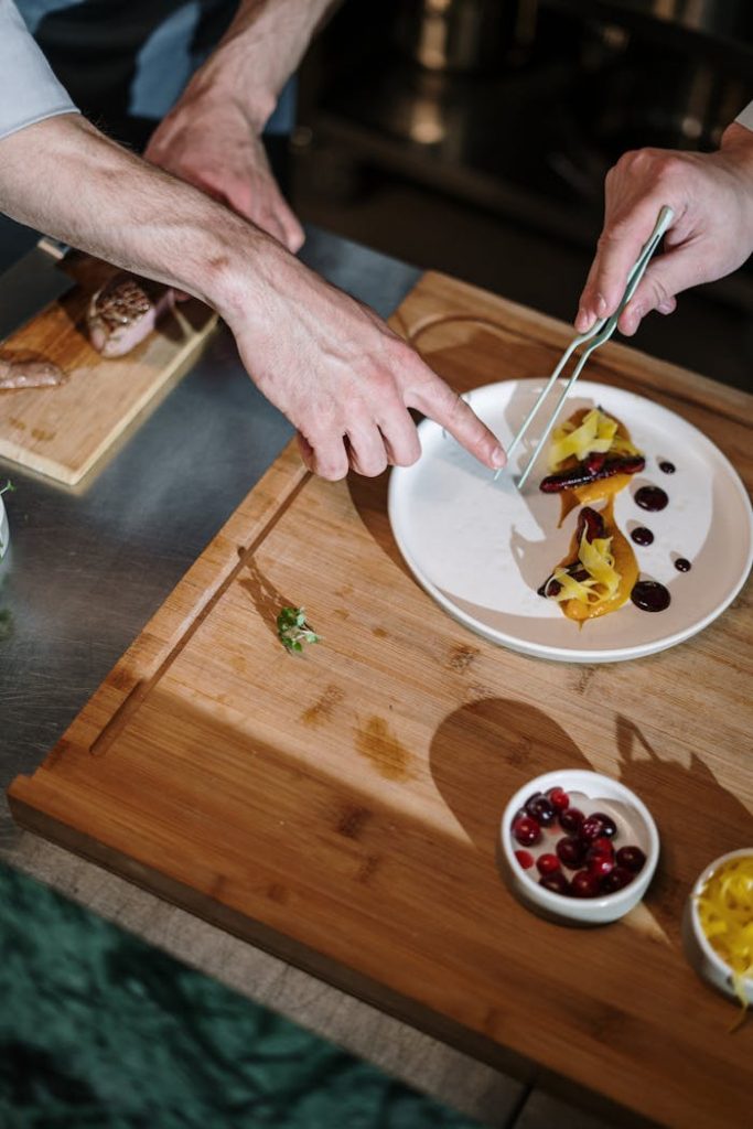 A chef expertly plating a gourmet dish in an upscale kitchen setting.